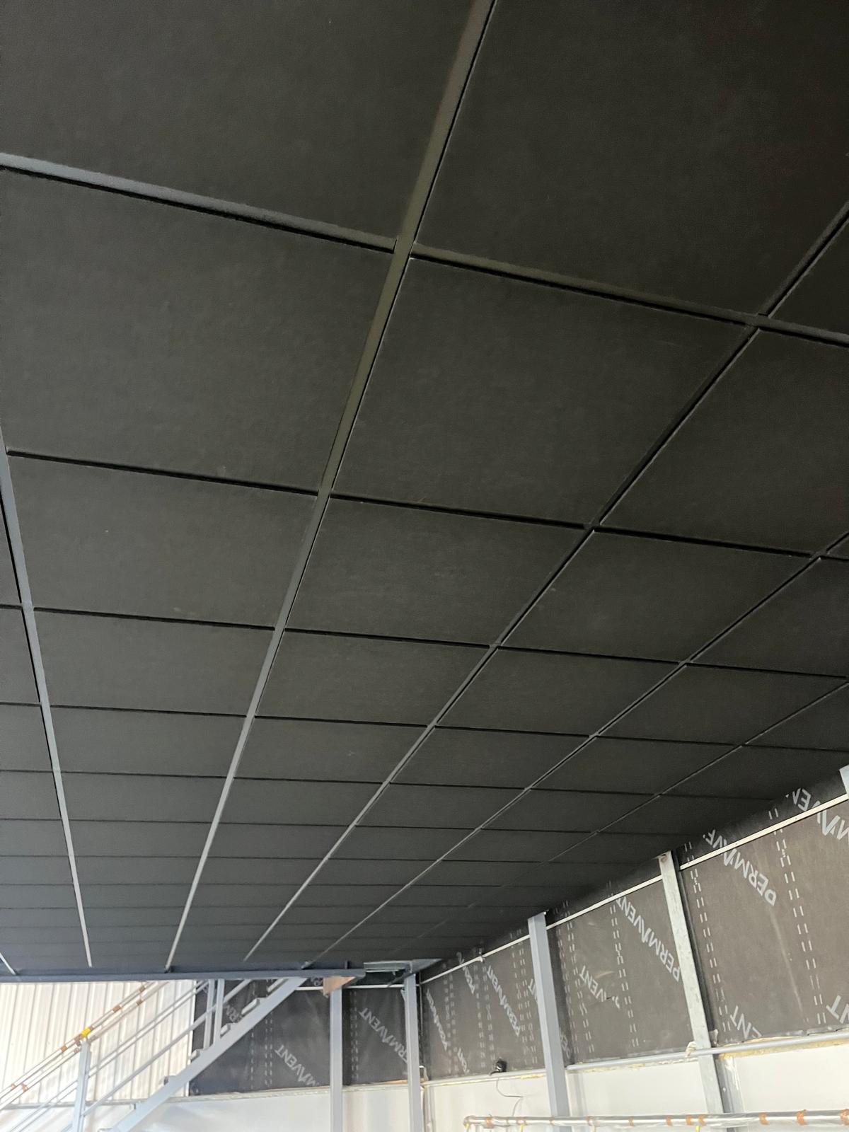 A suspended ceiling grid installed above a mezzanine office