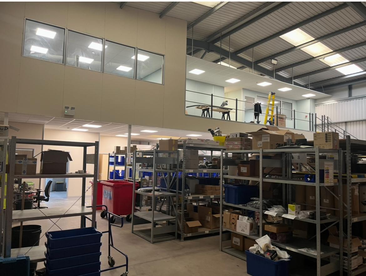 Mezzanine office with glazed screens above a stores and picking area